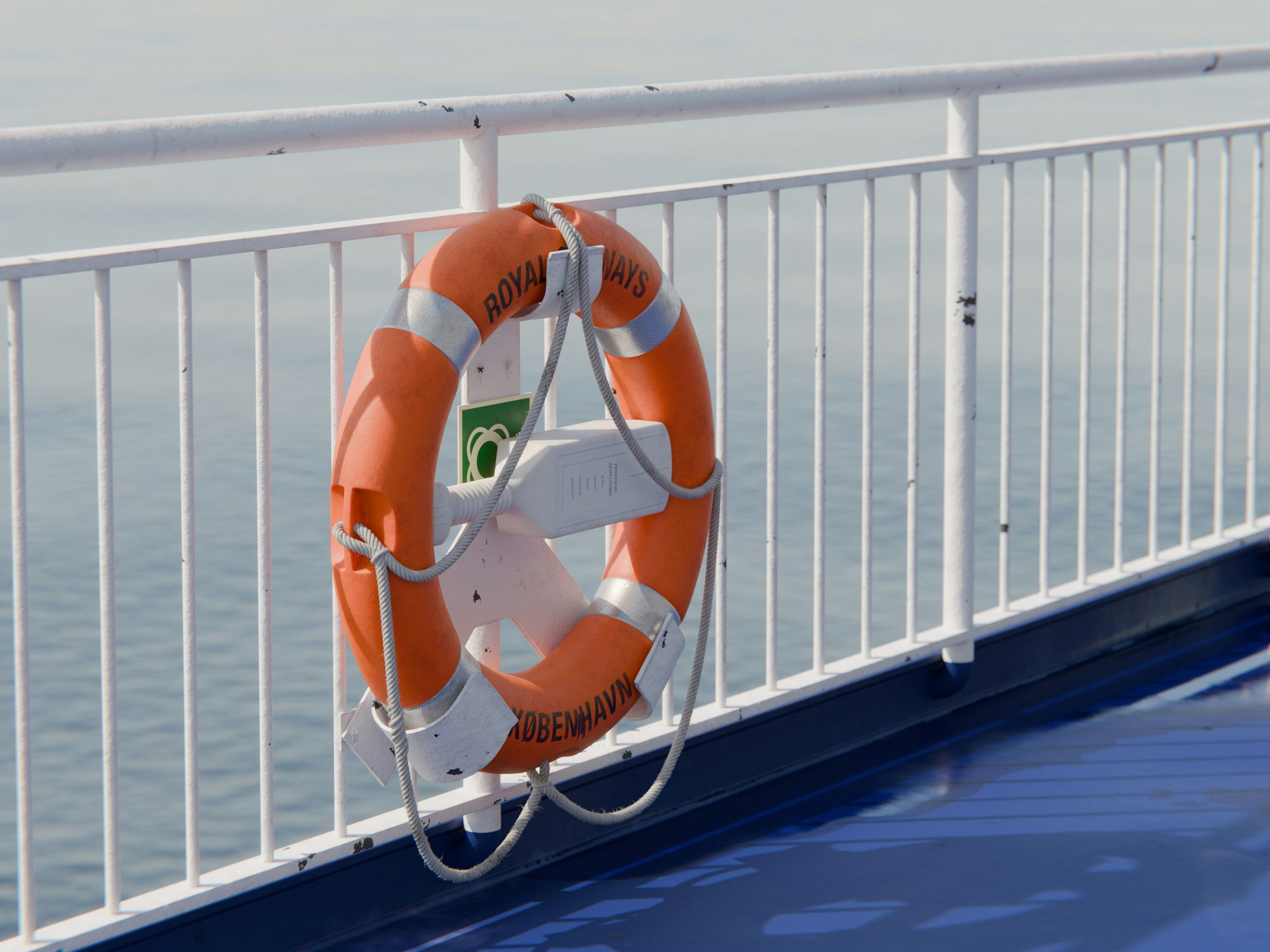 Maritime scene showing a lifebuoy hanging on the railing of a ship